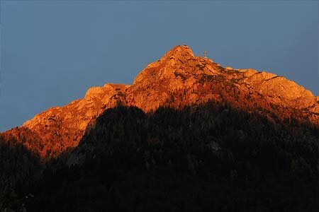 Poze turistice din Carpatii Meridionali. Fotografie a varfului muntelui Caraiman in lumina asfintitului.